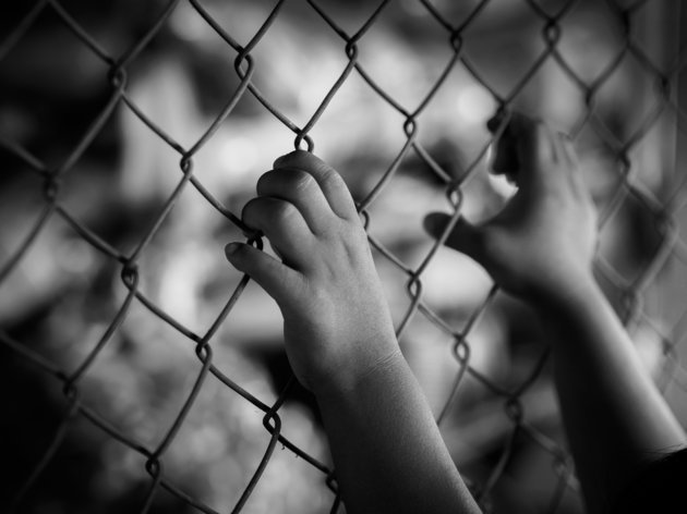 little girl hand holding on chain link fence for freedom, Human Rights Day, child labor, violence concept.