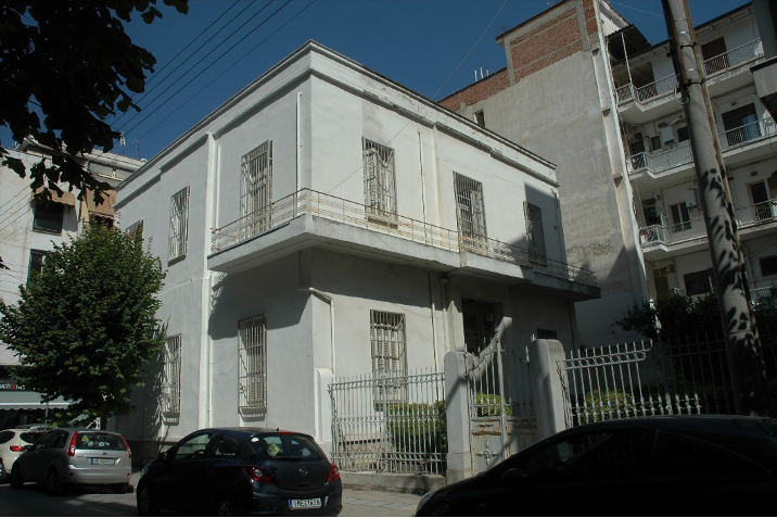 Η Οικία Αλεξάνδρου στη Λάρισα. Η νότια όψη στην οδό Παπακυριαζή και η ανατολική όψη στην αυλή, που διατηρούν την αρχική συμμετρία. Εμφανής ο τονισμός του κατακόρυφου άξονα συμμετρίας με την μικρή προβολή του μεσαίου τμήματος, τυπικό χαρακτηριστικό της νεοκλασικής αρχιτεκτονικής.